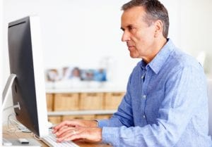 Man at computer writing an obituary